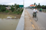 Asia;Camboya;Sudeste_Asiatico;tropico;zonas_tropicales;gente;personas;sociedad;razas_y_etnias;oriental_asiatico;camboyanos;entorno_urbano;puente;puentes;puente_sobre_rio;calles_y_avenidas;trafico;coches_circulando;vehiculos;vehiculos_circulando;gente_en_bicicleta;transporte;medios_transporte;transporte_terrestre;bicicleta;bicicletas;masas_agua;agua;rio;rios